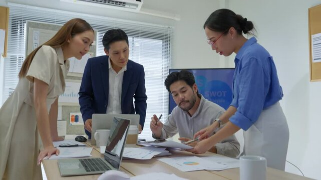 Asian business team standing together in modern office, brainstorming ideas while looking at a large digital screen, teamwork, strategy, innovation, collaboration orporate teamwork, planning, digital