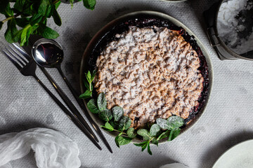 Round Pie with black currants and mint in a plate on the table. Dessert