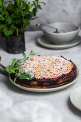 Round Pie with black currants and mint in a plate on the table. Dessert