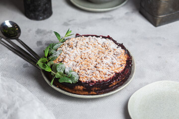 Round Pie with black currants and mint in a plate on the table. Dessert