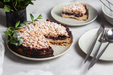 Round Pie with black currants and mint in a plate on the table. Dessert