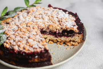 Round Pie with black currants and mint in a plate on the table. Dessert