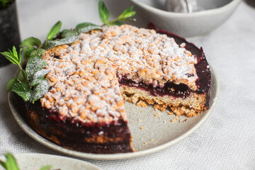 Round Pie with black currants and mint in a plate on the table. Dessert