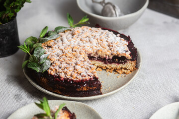 Round Pie with black currants and mint in a plate on the table. Dessert