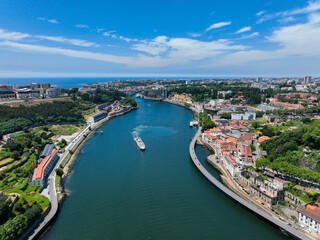 Obraz premium Wide aerial of the Douro River approaching the Atlantic with visible bridge