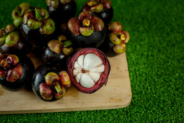 Fresh mangosteen fruits and cross section showing the thick purple skin and white flesh.