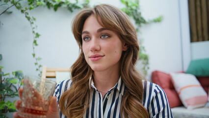 Beautiful girl sipping beverage sitting patio closeup. Woman drinking whiskey