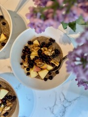 Healthy vitamin-rich balanced vegan breakfast. Raw flaxseed porridge with apples, walnuts, berries. Useful homemade veggie lunch. Vitamins, minerals. Gluten sugar free.	Lilac flowers in a frame.