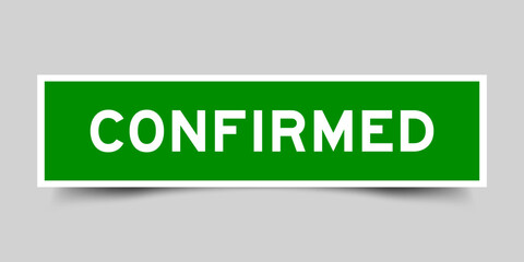 Green color square shape sticker label with word confirmed on gray background