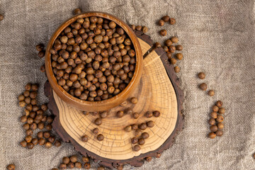 fried but not boiled chickpeas are on the table with a tablecloth, porridge is poured in a wooden bowl, top view