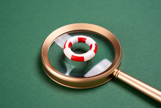 Magnifying glass and lifebuoy. Finding help and support. Mental health hotlines, crisis programs. Offer guidance and intervention when people are in need. Search for aid