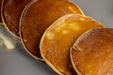 melting butter on hot freshly baked pancakes, several pancakes made from milk with flour on which...