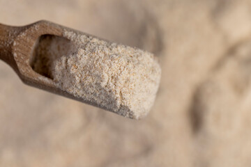 Fototapeta premium wheat flour for making bread with bran. flour in a spoon close up