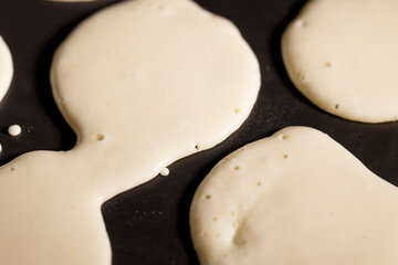 baking small pancakes with butter in a frying pan