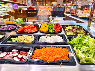 A salad bar featuring an extensive variety of fresh vegetables and fruits