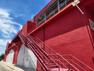 A set of stairs ascending a large red wall