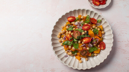 Fresh chickpea and pumpkin salad with tomatoes and herbs for healthy eating. Copy space