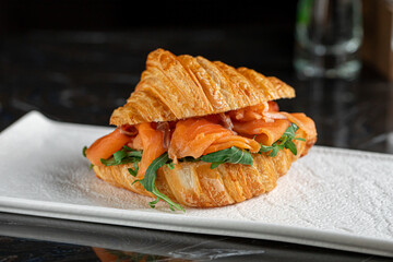Croissant breakfast sandwich with salmon and arugula