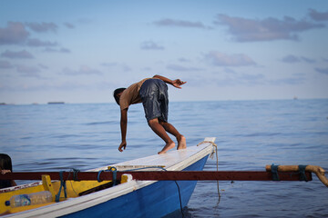 Children playing joyfully on a wooden boat in the sea,  playing together on the beach, riding a traditional wooden boat, having fun together.