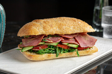 Portion of ciabatta sandwich with meat and salad