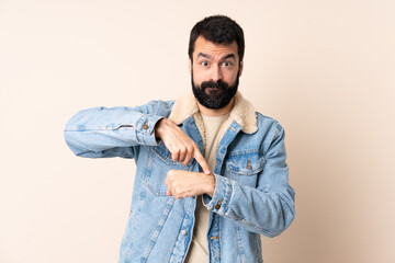 Fototapeta premium Caucasian man with beard over isolated background making the gesture of being late