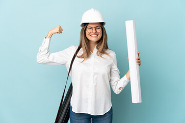 Slovak architect girl holding blueprints isolated on blue background doing strong gesture