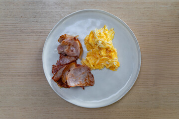 Breakfast plate of bacon and egg.