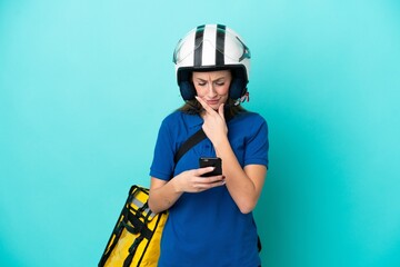 Young caucasian woman with thermal backpack isolated on white background thinking and sending a message