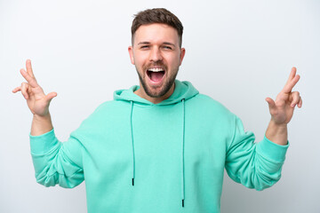 Fototapeta premium Young caucasian man isolated on white background with fingers crossing