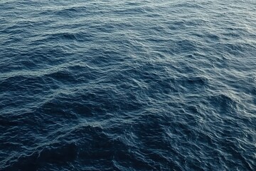 Detailed View of Ocean Water Texture with Sunlight Reflecting on the Ripples in Shades of Blue and Darker Depths Creating Abstract Natural Pattern