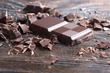 Broken dark chocolate on a wooden table