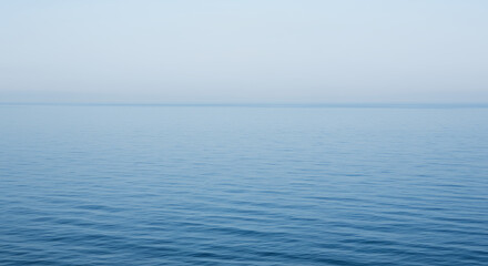 Obraz premium Serene Ocean: Calm Blue Waters, Peaceful Horizon, and Misty Sky | Nature's Tranquility