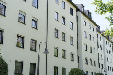 Modern apartment building showcasing clean architectural lines and greenery on a sunny day in a residential neighborhood