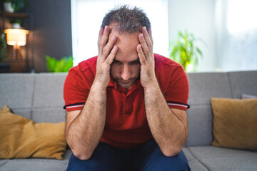Man sitting alone at home looking sad and distraught