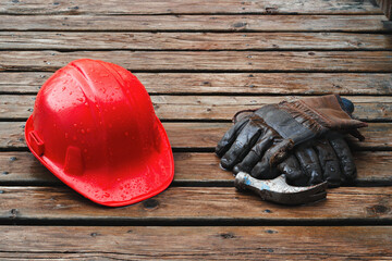 Hard hat, work gloves and hammer on a wet day