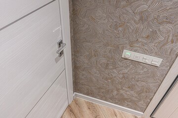 close-up shot showcases a modern interior: a light wood door with a silver handle, textured brown...