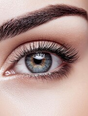 Fototapeta premium Close-up of a person's eye. the eye is blue and the iris is a light brown color. the eyelashes are long and full, and they are a darker shade of brown.