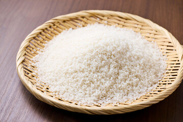 Raw Japanese rice in a bamboo sieve