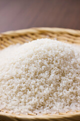 Raw Japanese rice in a bamboo sieve