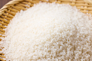 Raw Japanese rice in a bamboo sieve