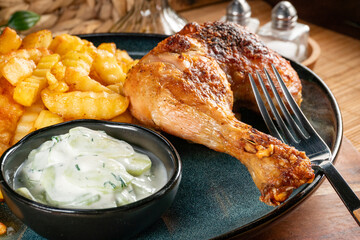 Crispy roasted chicken leg with french fries.