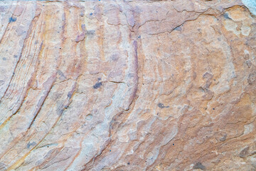 close-up view of layered sandstone with rich brown and orange tones, showcasing organic striations...