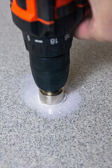 rotating diamond core hole saw drilling into a stone slab