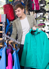 Male shopper chooses sports jacket for outdoor sports