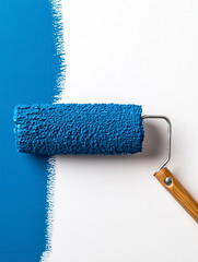 Obraz premium A paint roller with fresh blue paint, partially used, isolated on white