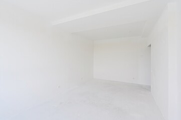 empty, all-white room with a doorway leading to another space. The walls are plain, and the floor is bare. Minimalist and clean aesthetic.