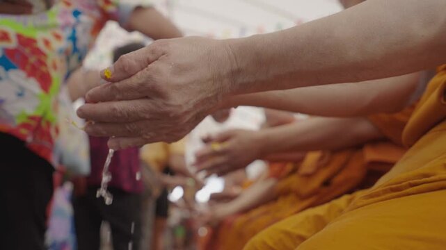 Buddhists gather to perform the ritual bathing of monks to receive blessings and good fortune during the Songkran Festival.