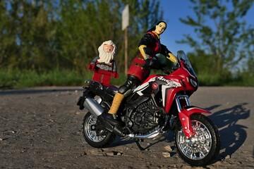 Obraz premium GI JOE female action figure of intelligence agent Jinx, version 2004 by Hasbro, sitting on model of dual sport motorbike Honda Africa Twin with LEGO Hobit dwarf Balin, standing on bike rear part. 