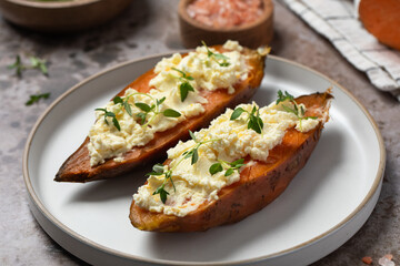 Baked sweet potatoes with ricotta and fresh herbs. Healthy and vegan food