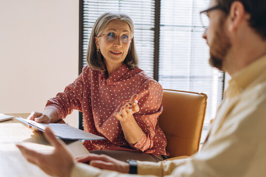 Senior businesswoman discussing with colleague during business meeting